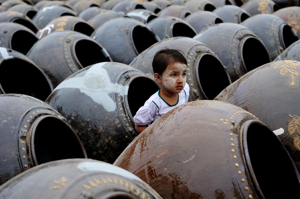 man in blue shirt standing in front of brown wooden barrels