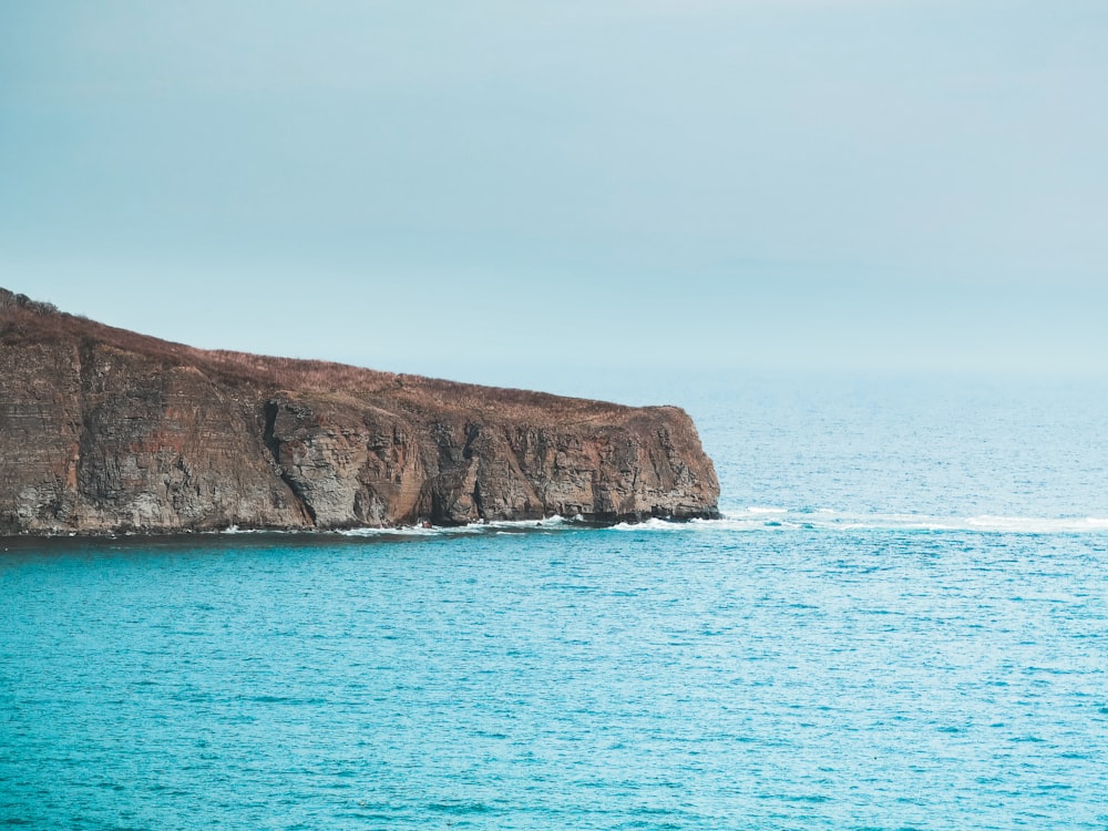 brown rock formation on sea during daytime