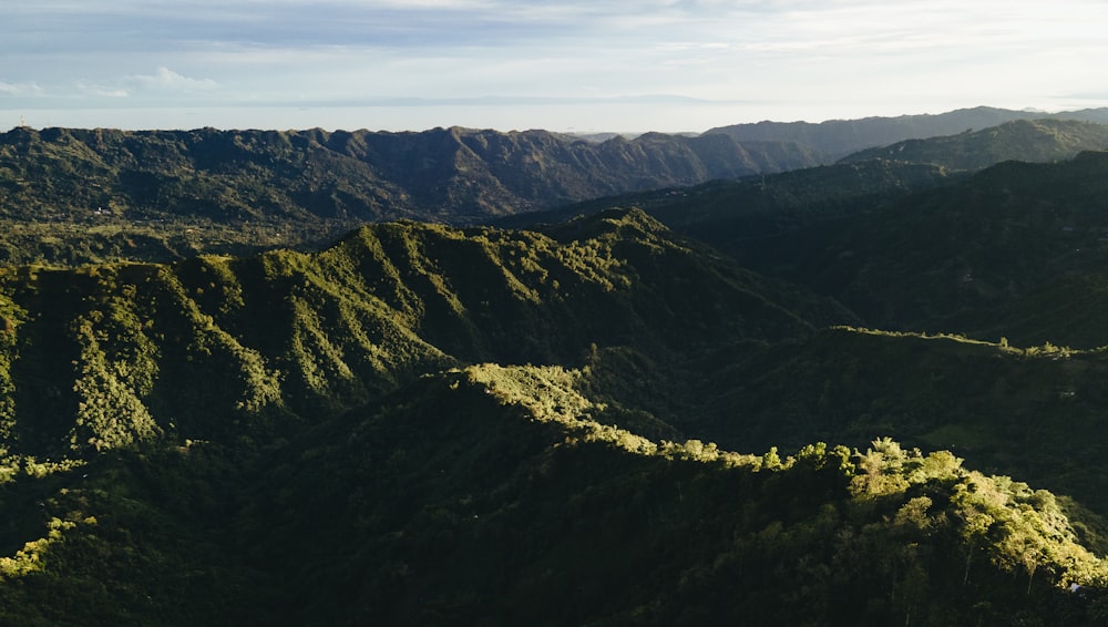 green and brown mountains under white clouds and blue sky during daytime