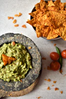 A vibrant bowl of guacamole with tortilla chips ready to be shared.