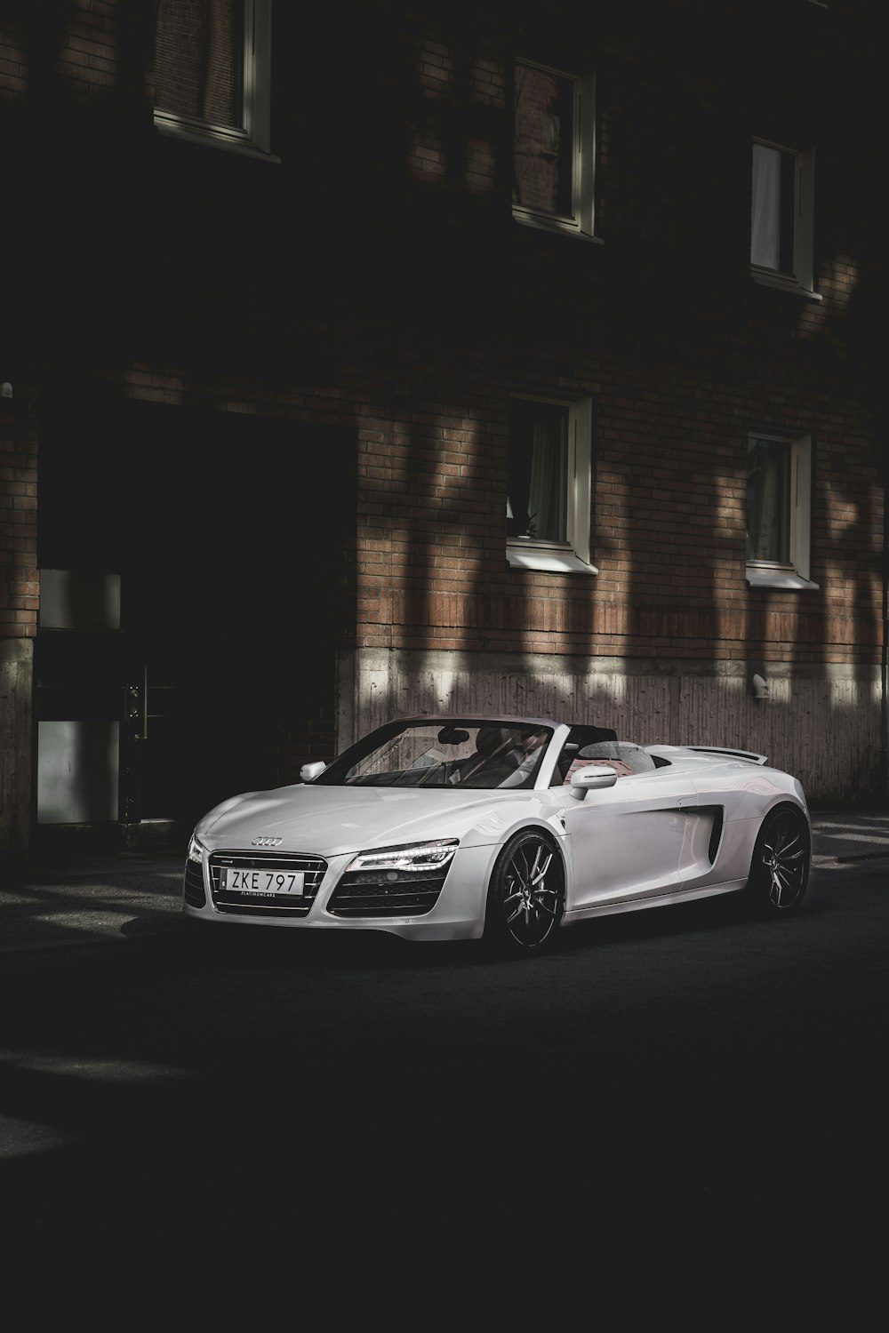 white mercedes benz coupe parked beside brown building during night time