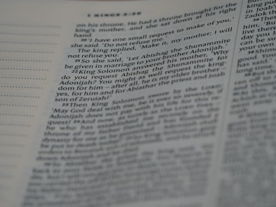 A close-up view of a page from a book with text in English. The text is organized in paragraphs with numbered sections, resembling a Bible or similar religious text. The focus is mainly on one column while the rest is slightly blurred.