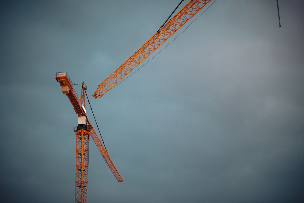 yellow crane under cloudy sky during daytime