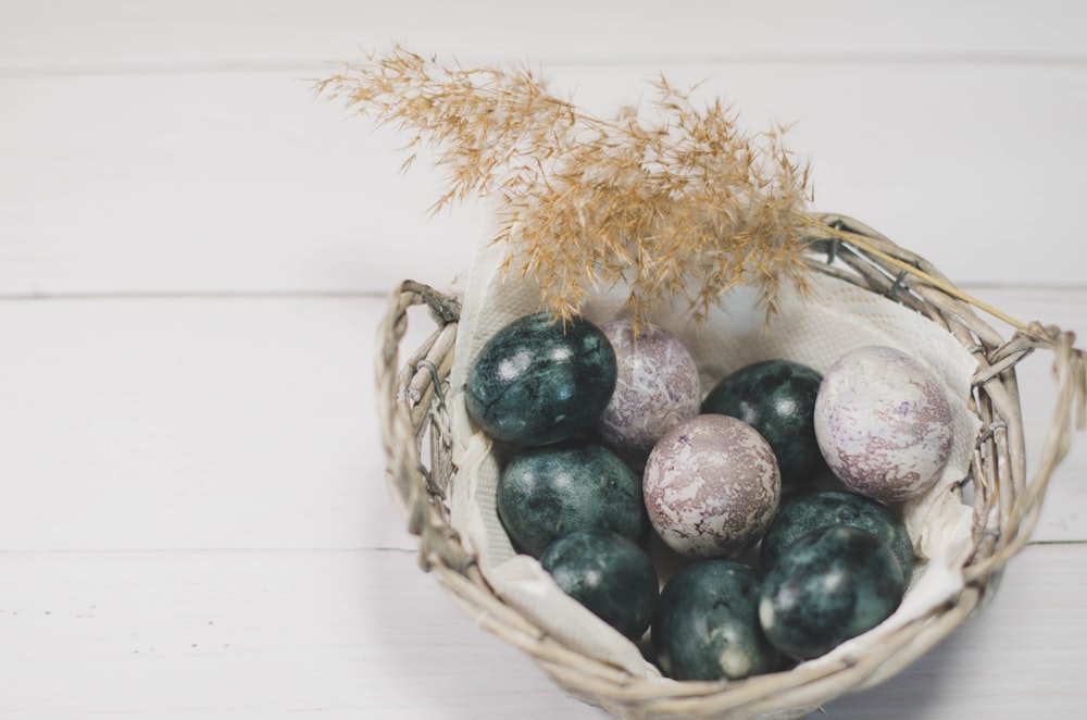 blue and brown egg on brown woven basket