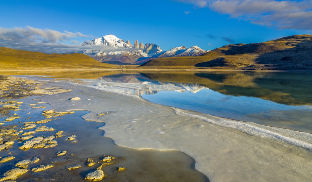 lake near mountain under blue sky during daytime