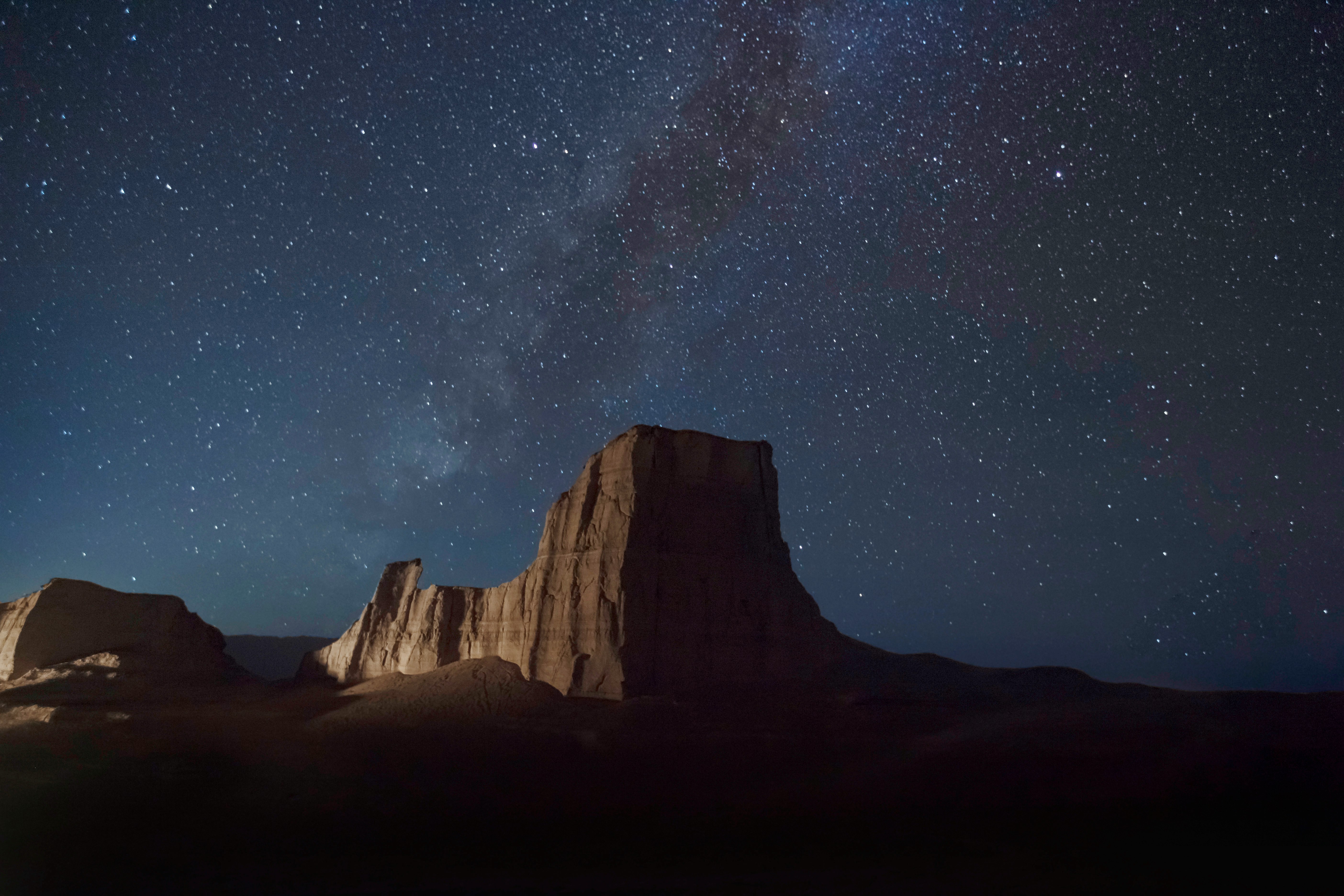 brown rocky mountain under starry night