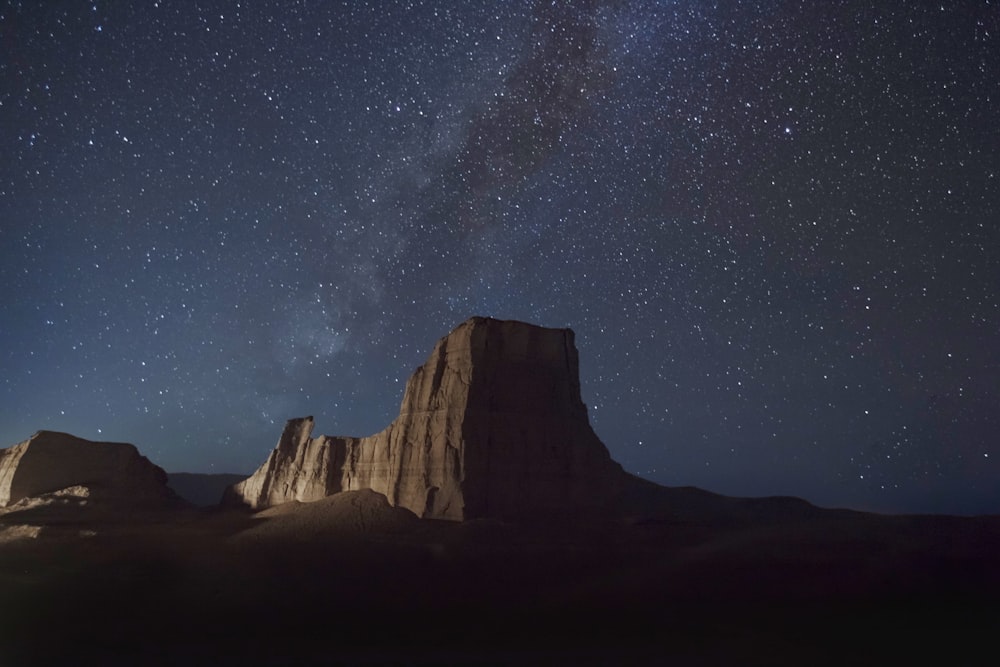 brown rocky mountain under starry night