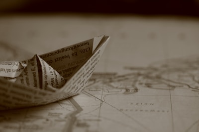 A close-up of hands crafting a small paper boat, representing daily creative challenges.