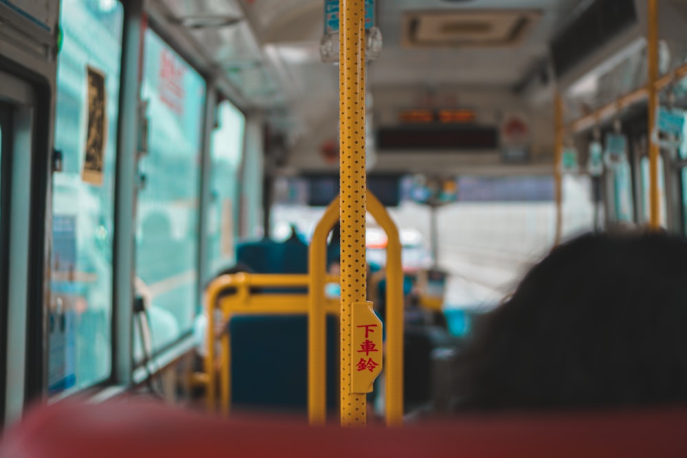 yellow metal bar in front of white and red bus