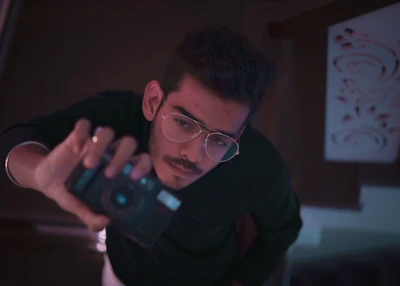 man in black long sleeve shirt holding black smartphone