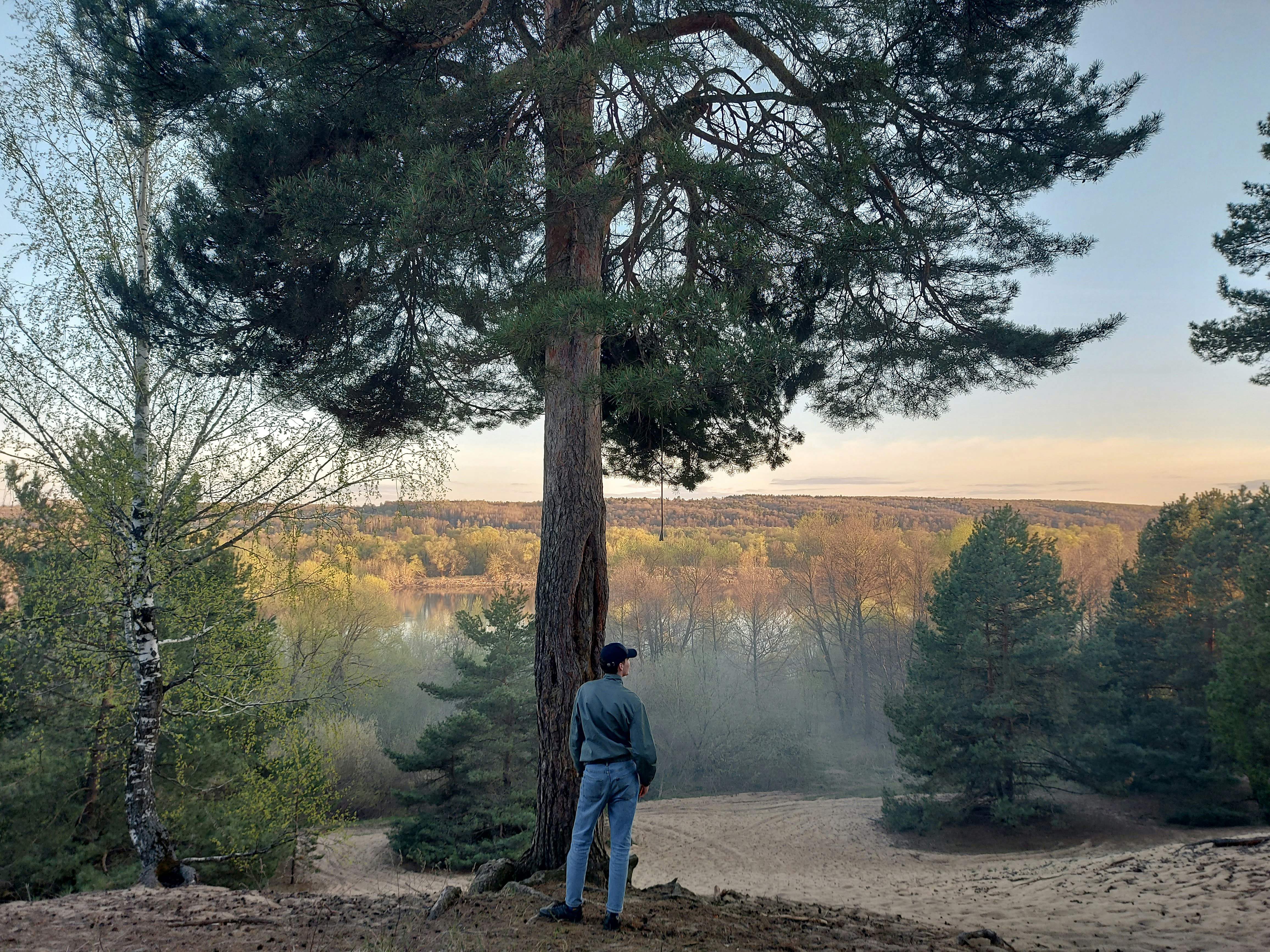 man in blue jacket standing near lake during daytime