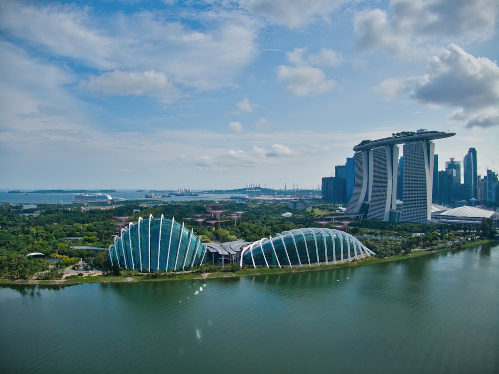 body of water near city buildings under blue and white sunny cloudy sky during daytime