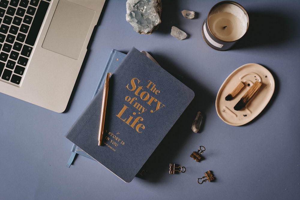 Un libro sentado encima de una mesa junto a una computadora portátil