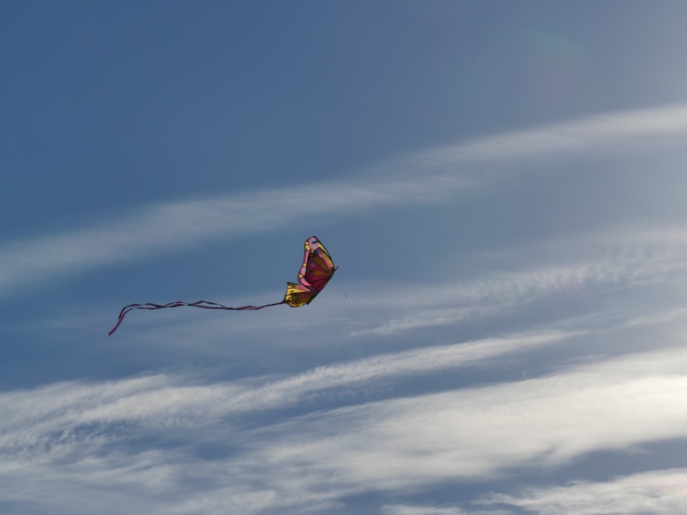 red and yellow kite flying under blue sky during daytime