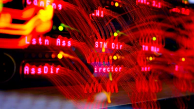 Close-up of a Fortinet firewall device with glowing indicator lights in a server room.