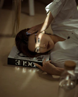 woman in white button up shirt lying on bed