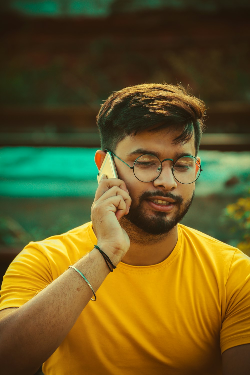 a man with glasses talking on a cell phone
