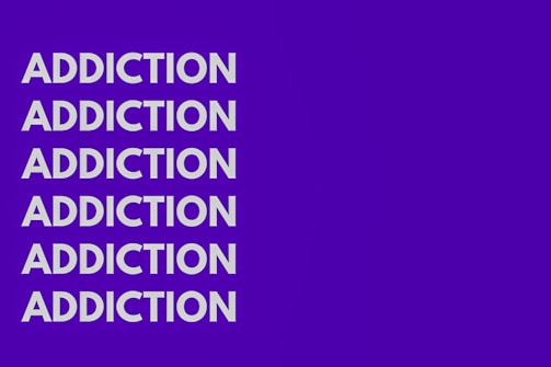 The image features the word 'ADDICTION' repeated six times vertically in bold, white capital letters against a solid purple background.