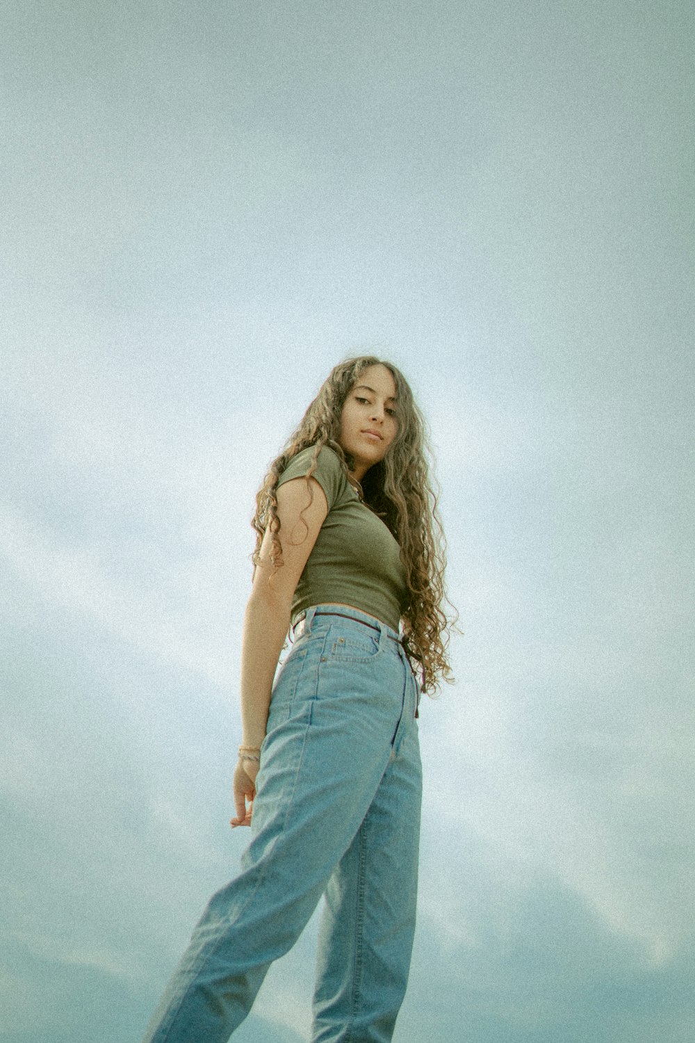 woman in brown tank top and blue denim jeans