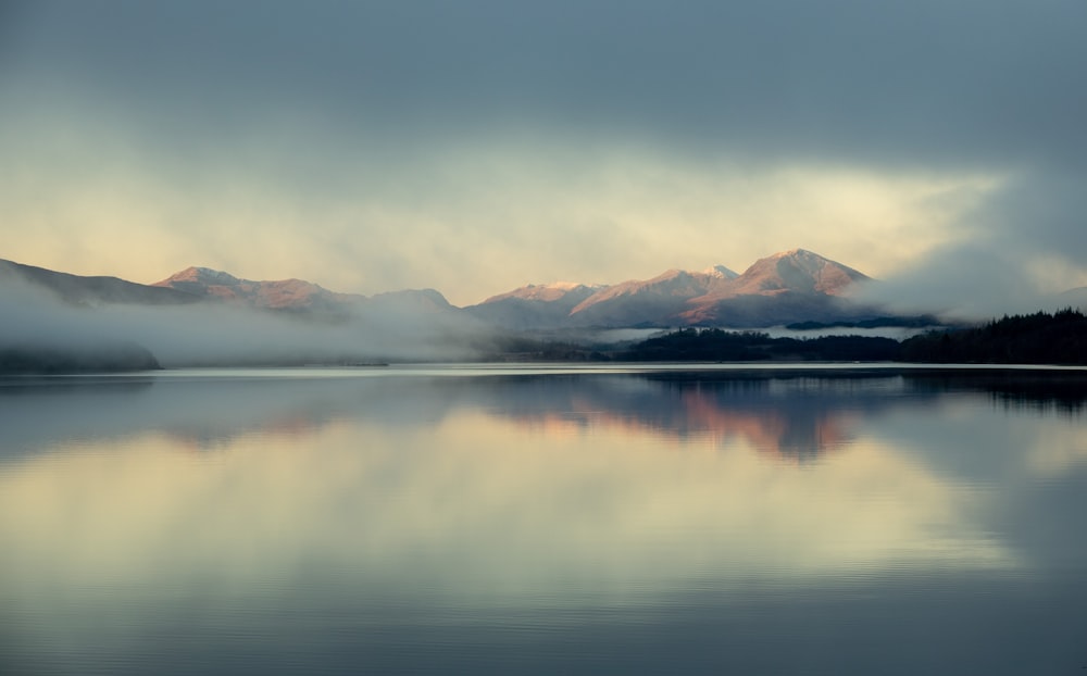 body of water near mountain during daytime