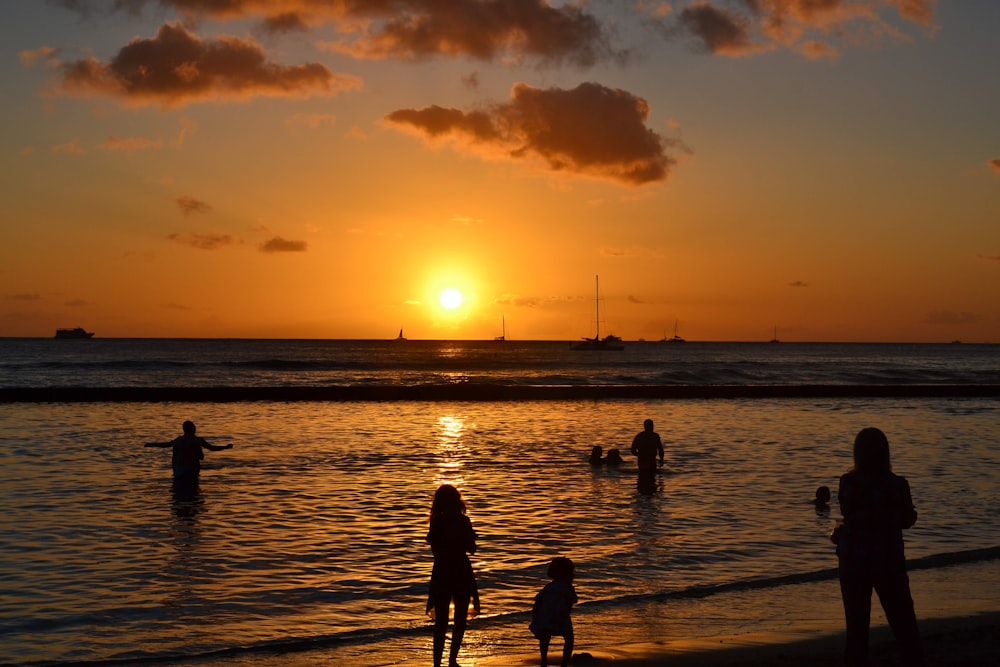 silhouette of people on beach during sunset