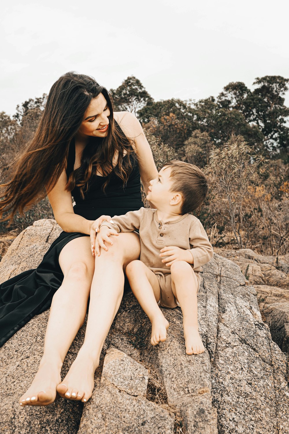 woman in black dress carrying girl in brown dress