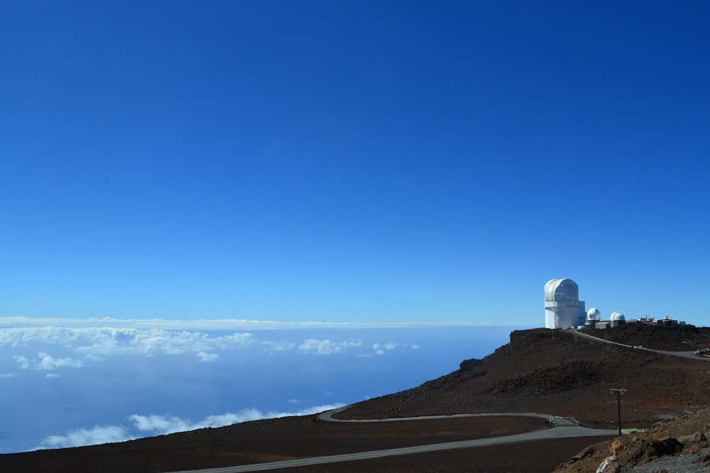 white lighthouse on top of hill during daytime