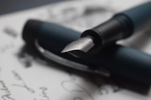 Close-up of a classic fountain pen resting on a trust agreement paper