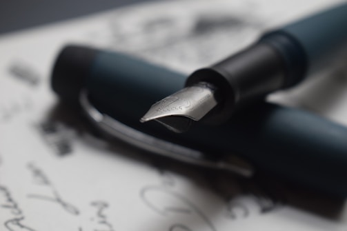Close-up of a fountain pen nib poised over parchment, symbolizing meticulous legal drafting.