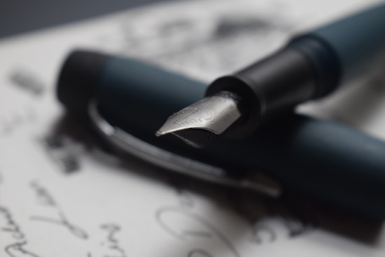 A close-up of a fountain pen resting on a smooth notebook page, showcasing elegant writing.