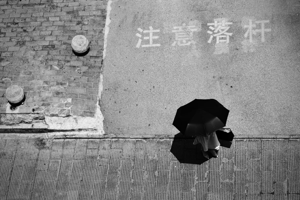 우산을 들고 있는 사람의 그레이스케일 사진
