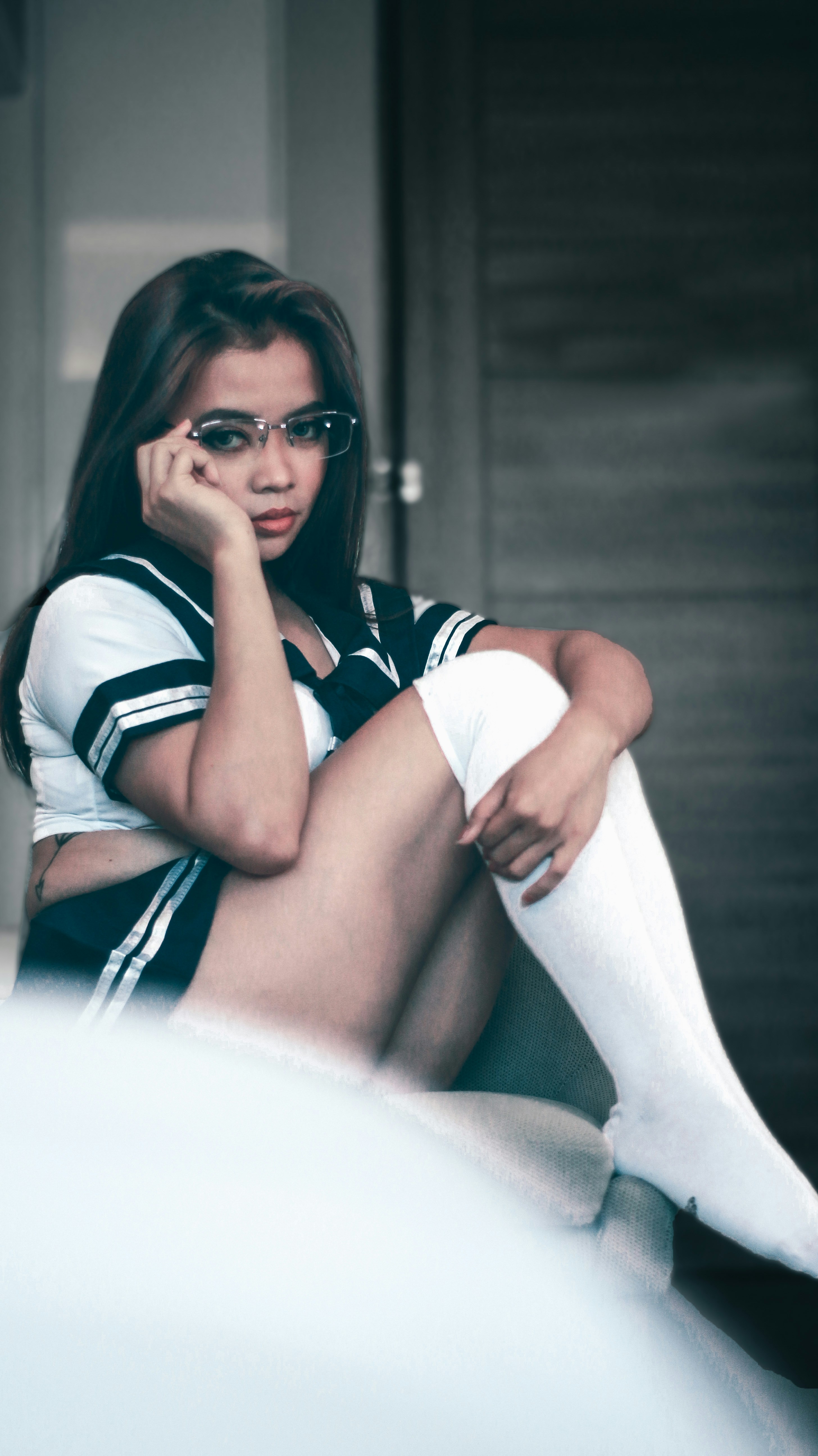 wanita dengan kemeja garis putih dan hitam dan celana putih mengenakan kacamata hitam