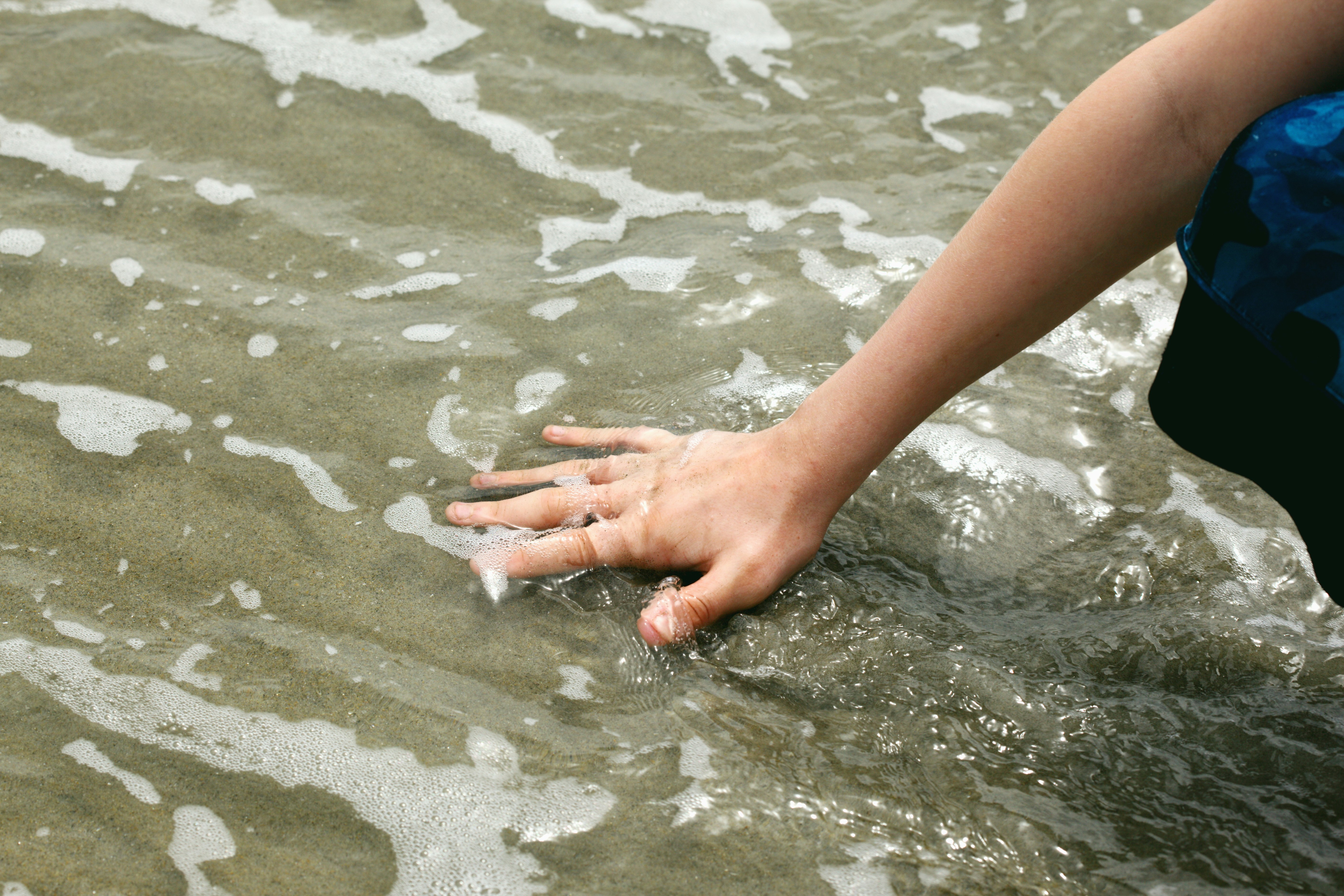 Hand in ocean water.