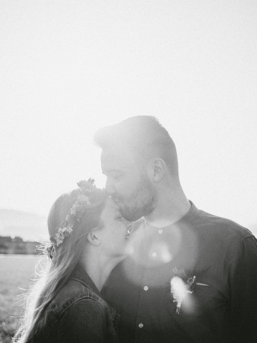 man and woman kissing grayscale photo