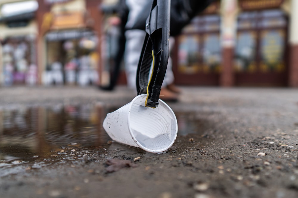 Cubo de plástico blanco sobre suelo mojado