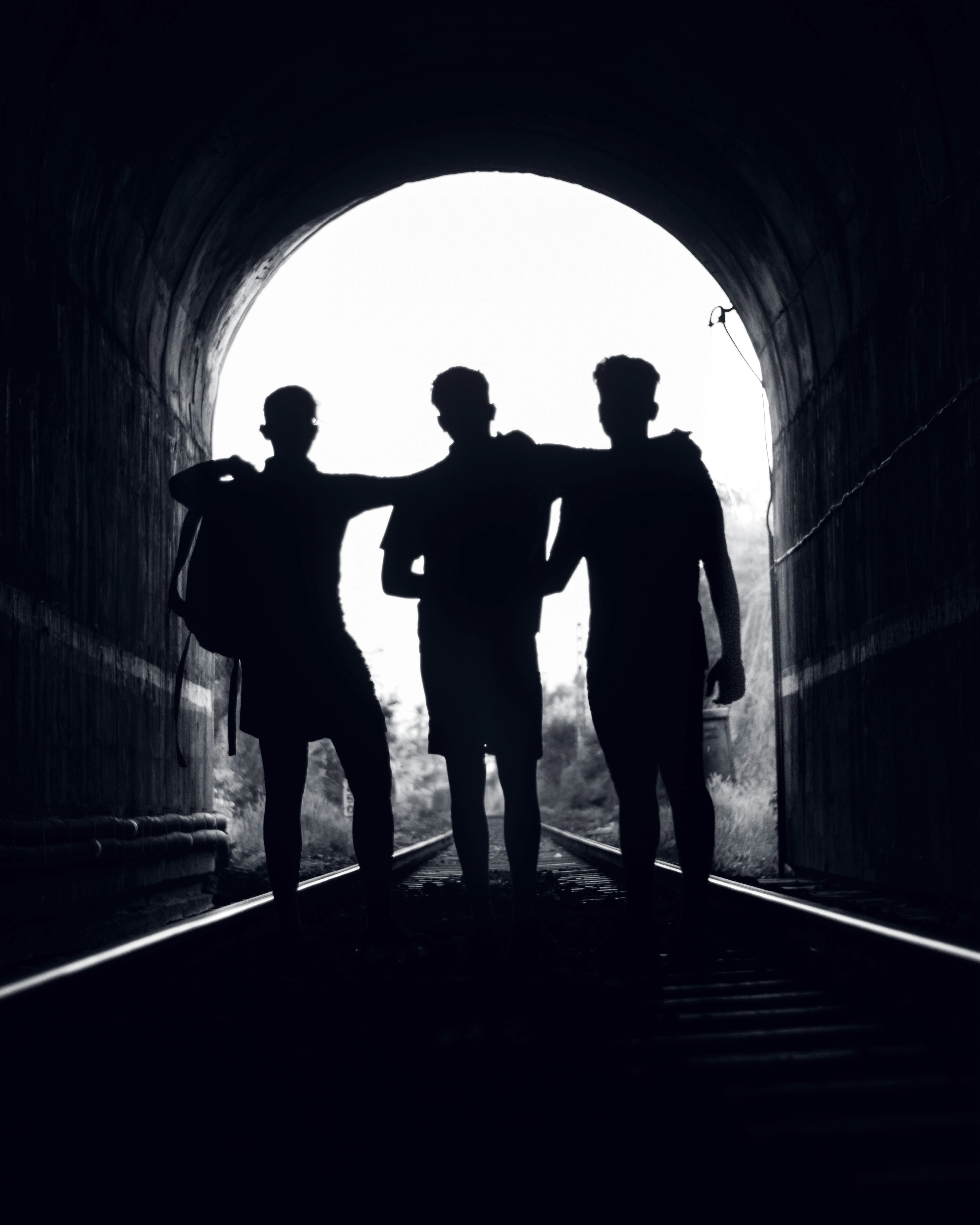 silhouette of people walking on tunnel