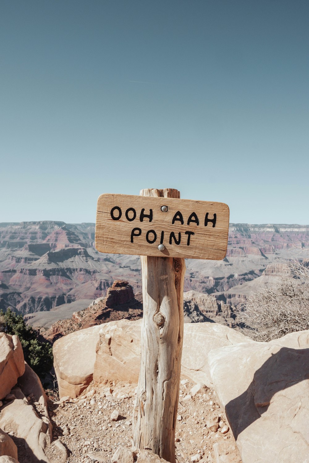 brown wooden signage on brown rock mountain during daytime