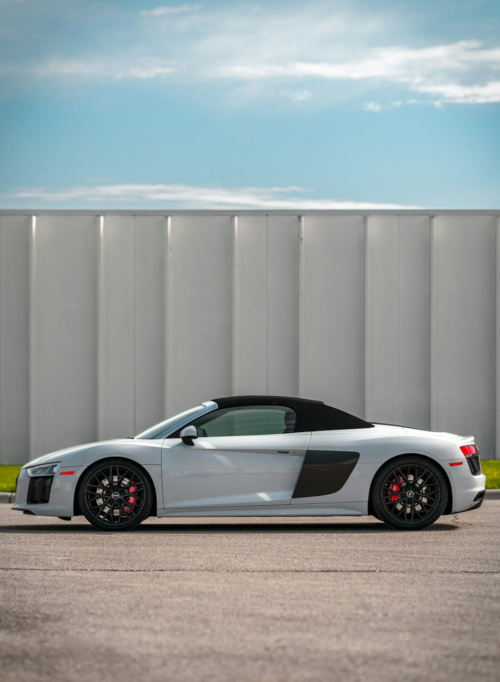 silver porsche 911 parked near white wall