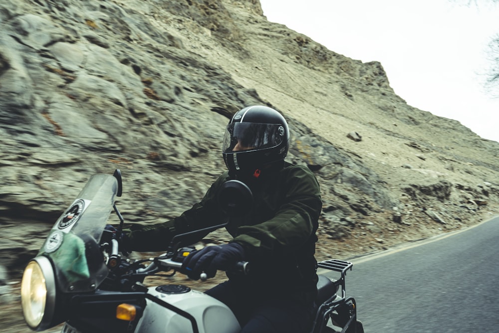 man in black helmet riding on white and black motorcycle during daytime