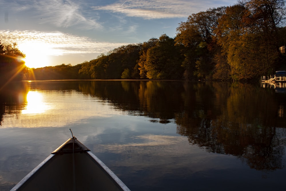 white boat on lake near trees during daytime