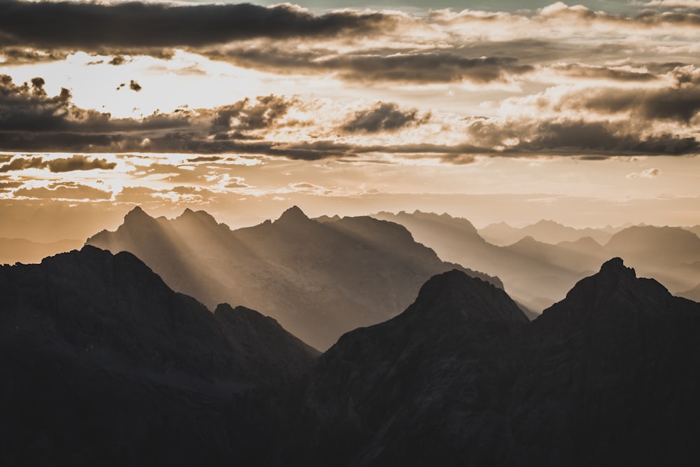 Schwarze Berge tagsüber unter weißen Wolken