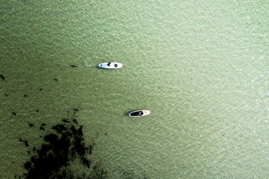 aerial view of white boat on green sea during daytime
