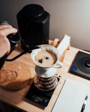 person pouring coffee on white ceramic mug