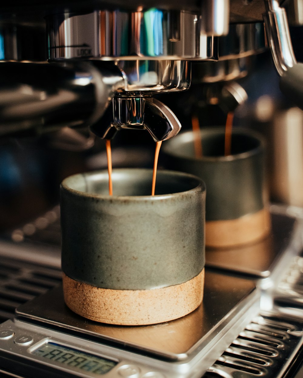 taza de cerámica blanca sobre cafetera negra y plateada