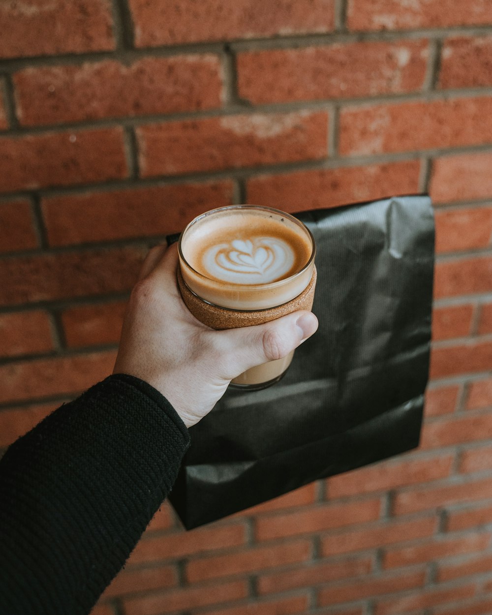 Persona sosteniendo un capuchino en una taza