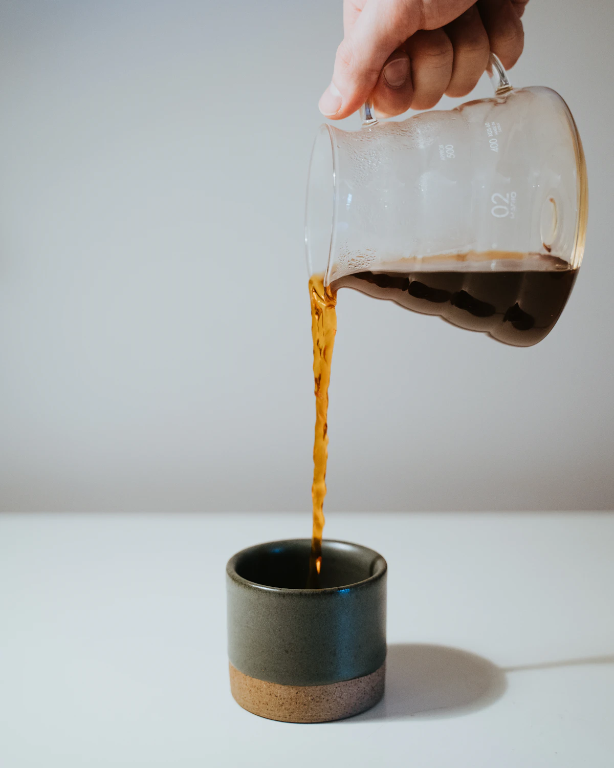 Pouring water over coffee in a ceramic mug