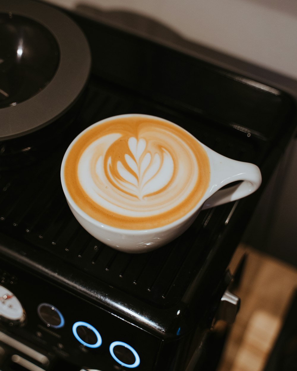 taza de cerámica blanca con capuchino