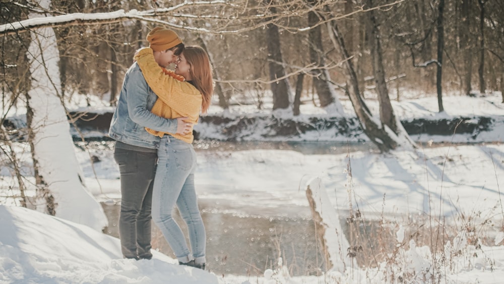 woman in gray jacket and blue denim jeans standing on snow covered ground during daytime