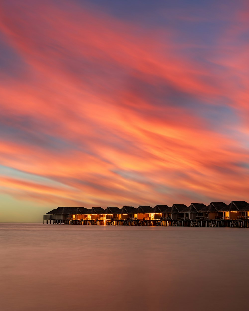 silhouette of building on sea during sunset