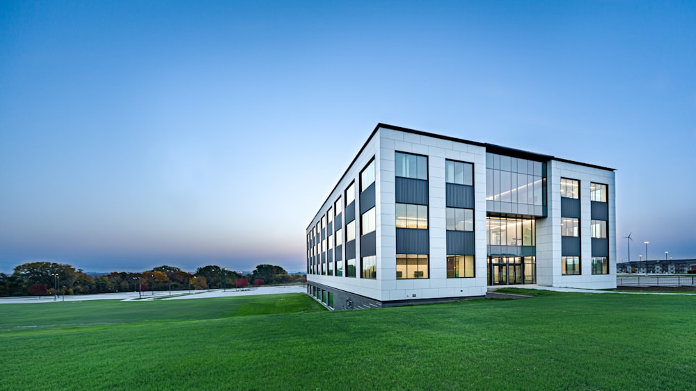 white concrete building on green grass field under blue sky during daytime